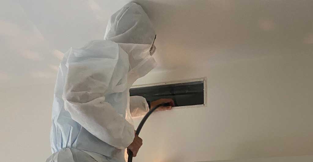 Personal limpiando los conductos de aire acondicionado