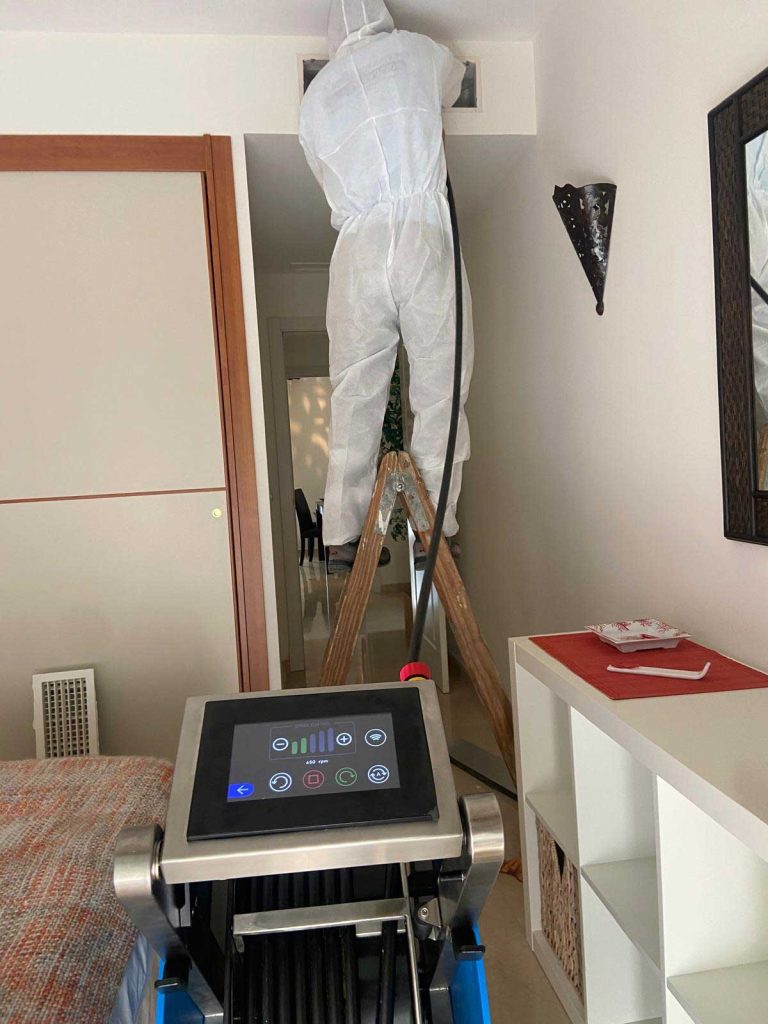 Personal limpiando los conductos de aire acondicionado