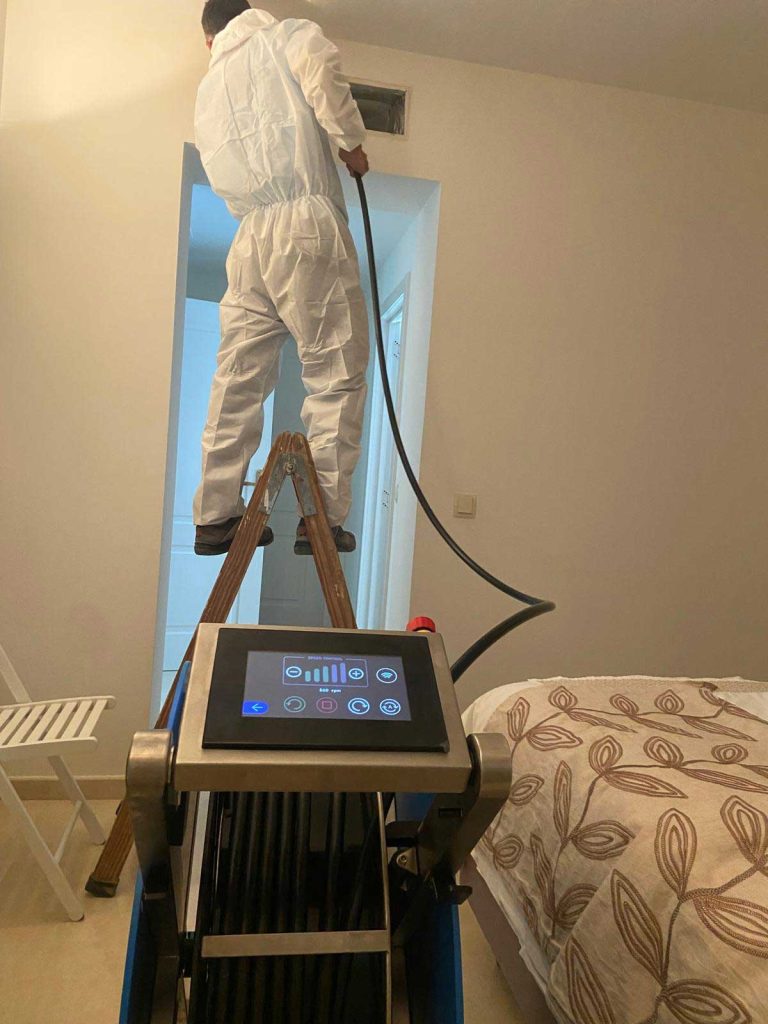 Personal limpiando los conductos de aire acondicionado