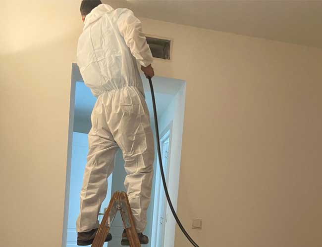 Personal limpiando conducto de aire acondicionado